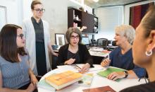 Lois talking with her staff around a table