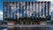 Photo of the Law School building with an overlay of a world map on the windows as reflections of clouds