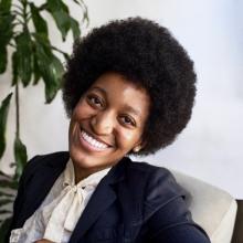 Woman with her head tilted to the side smiling at the camera