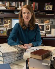 Alison LaCroix sits at her desk with a stack of The Interbellum Constitution