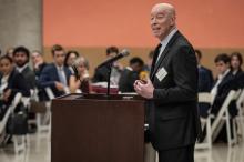 Craig Futterman stands at a lectern addressing a seated audience