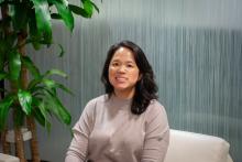Sue Pak sitting on a chair smiling for the camera