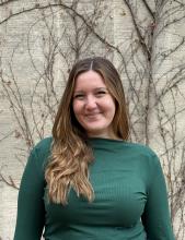 A photo of Caroline Kassir, a young woman in a green sweater.