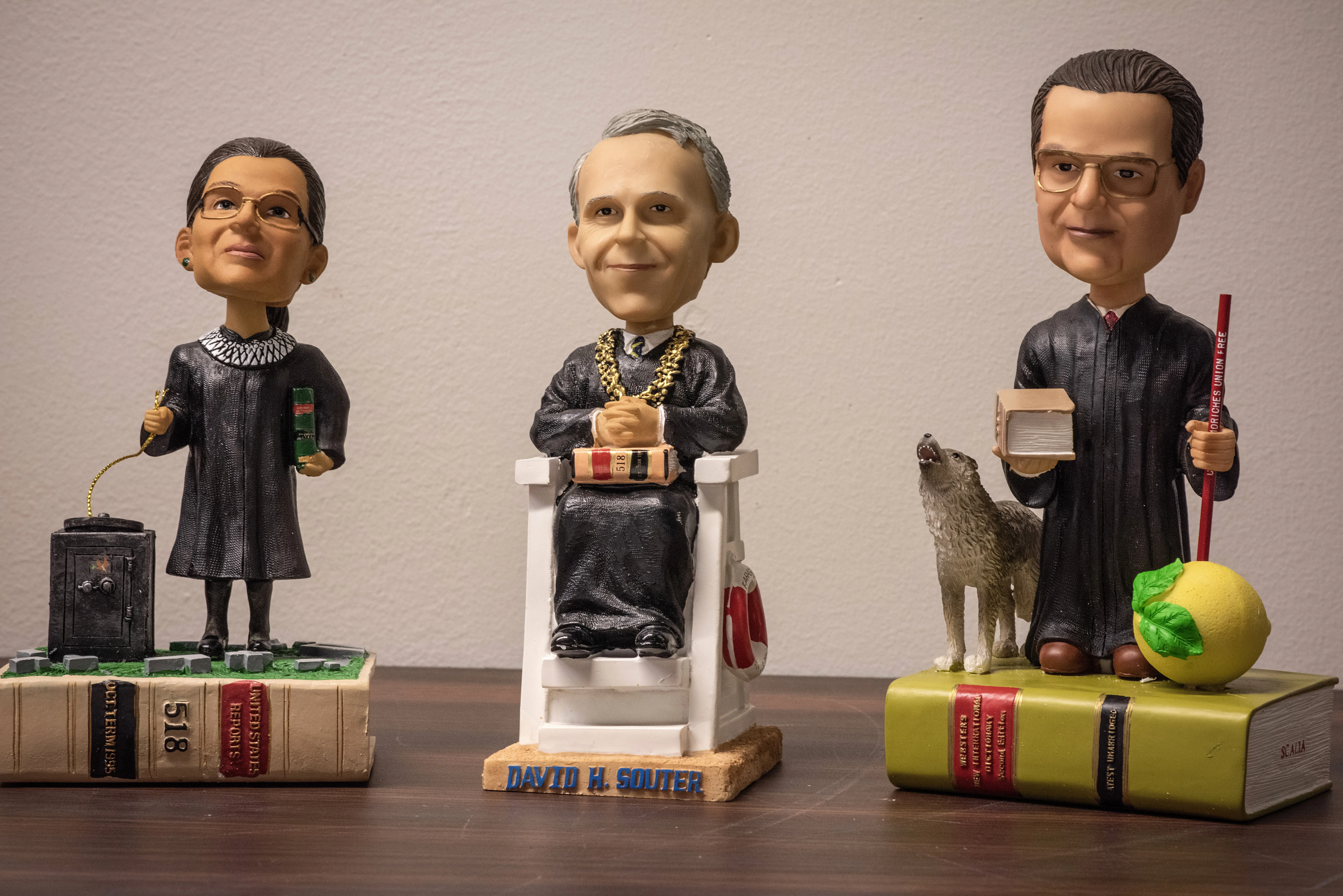 3 figurines each on top of a small book.