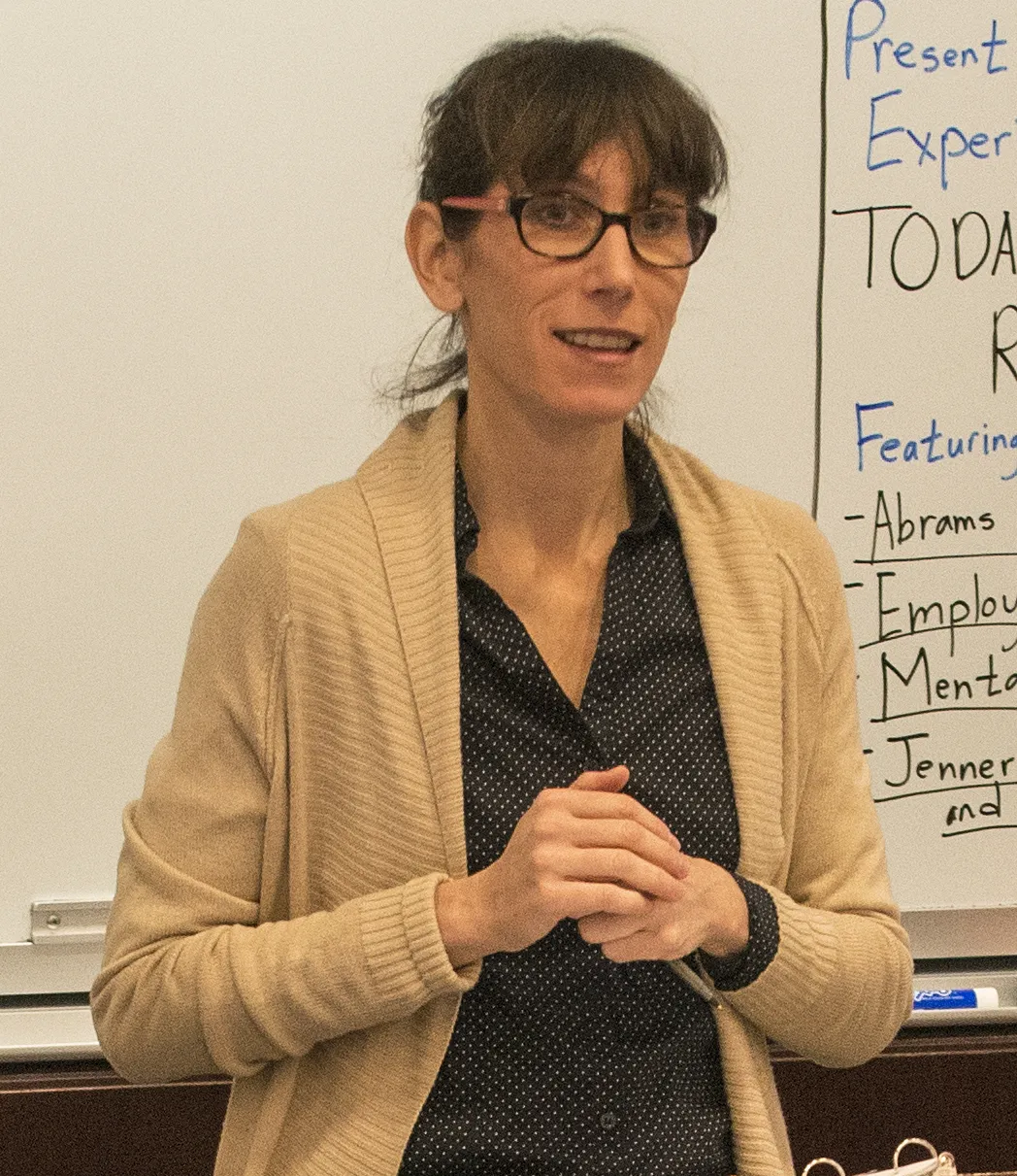 Genevieve Lakier standing in front of a whiteboard