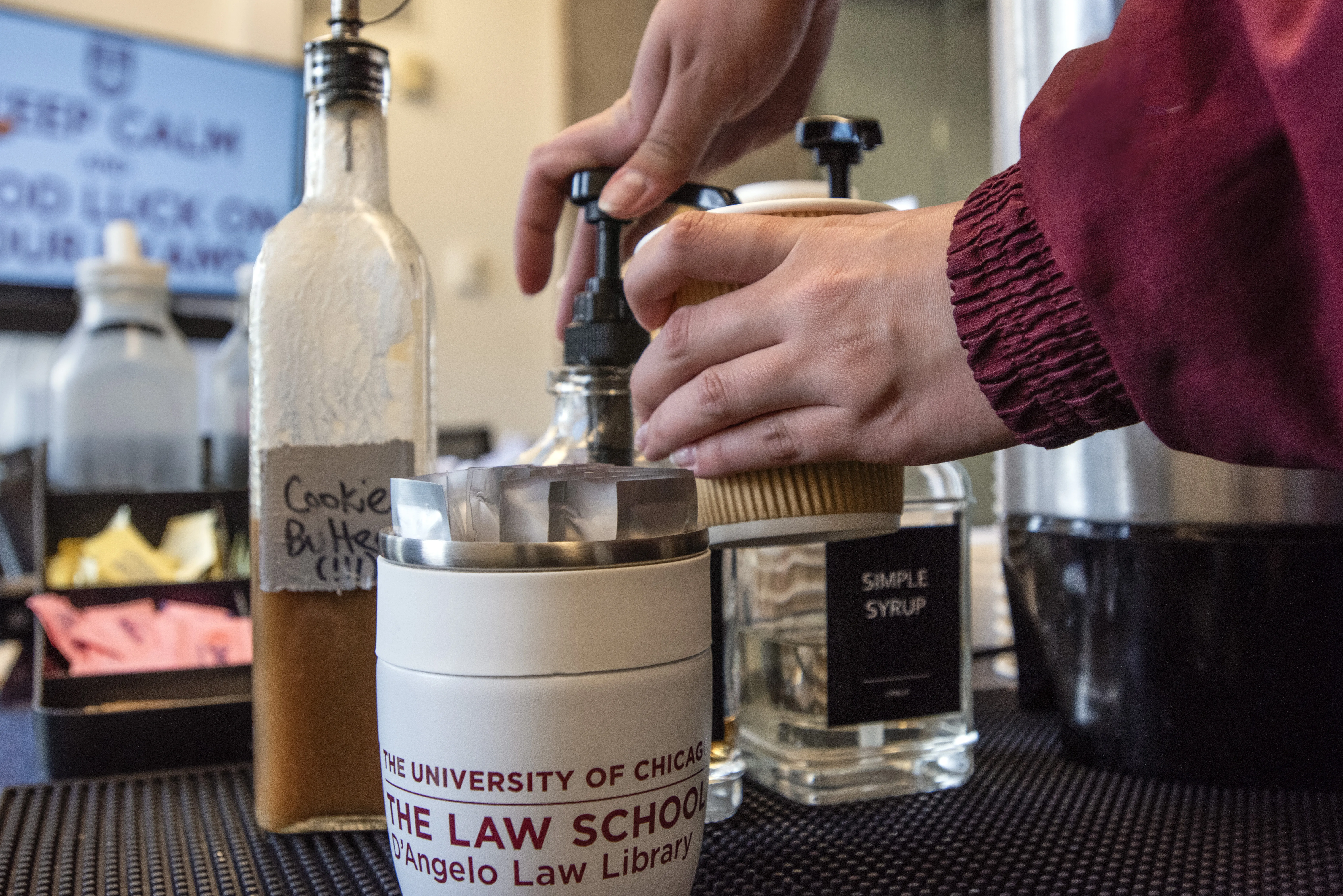 Student adding to coffee cup