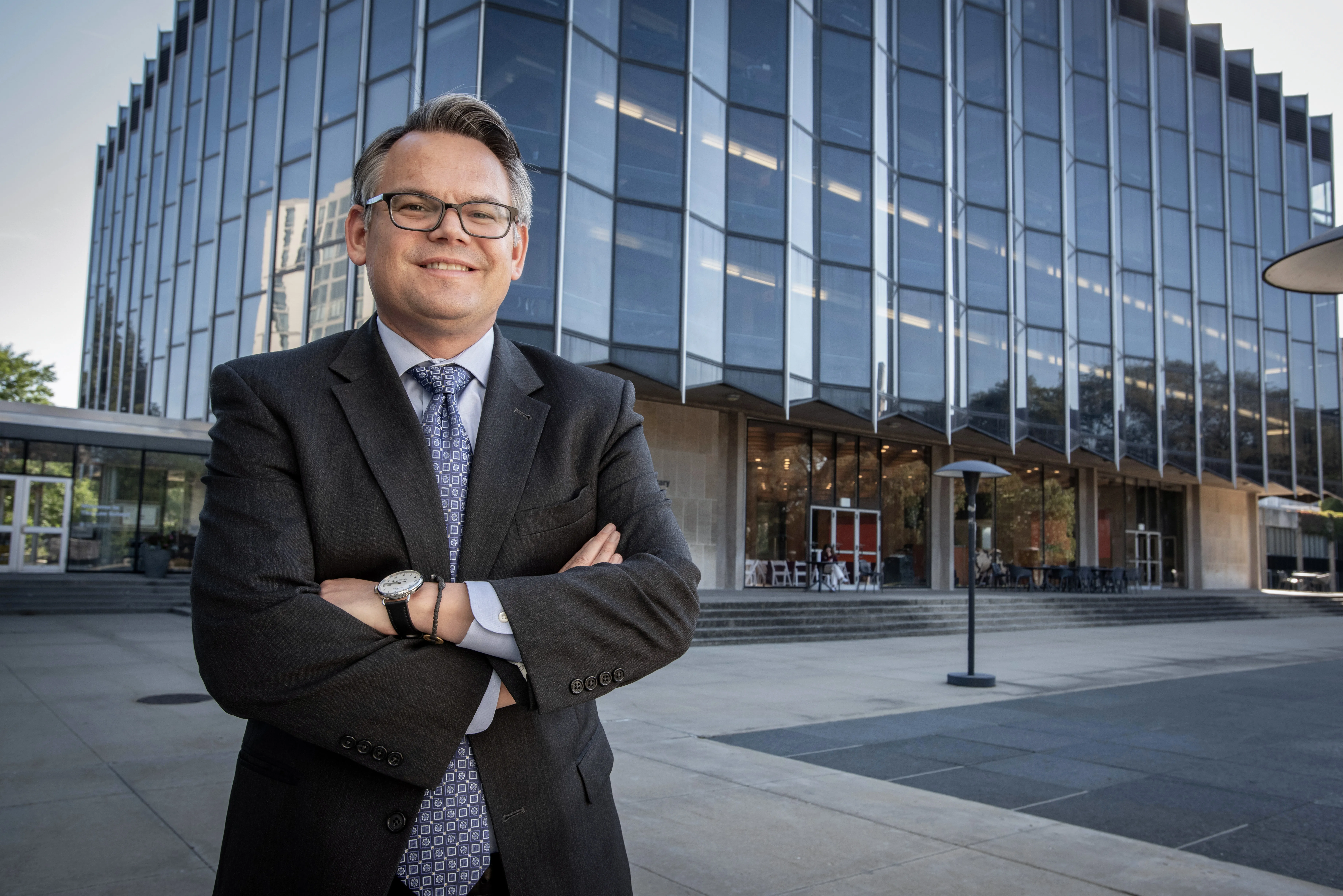 Dean Chilton standing in front of Law School with arms crossed