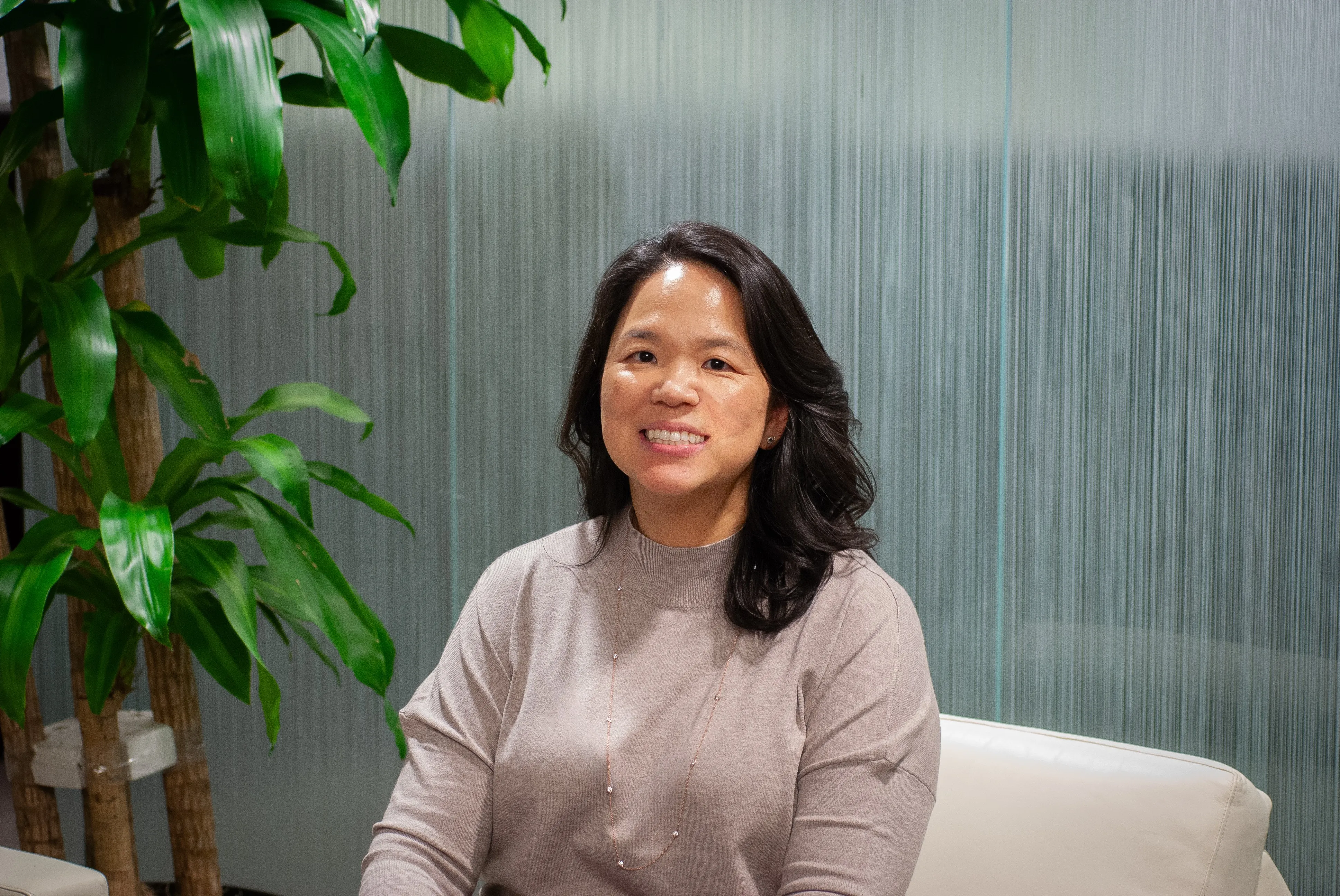 Sue Pak sitting on a chair smiling for the camera