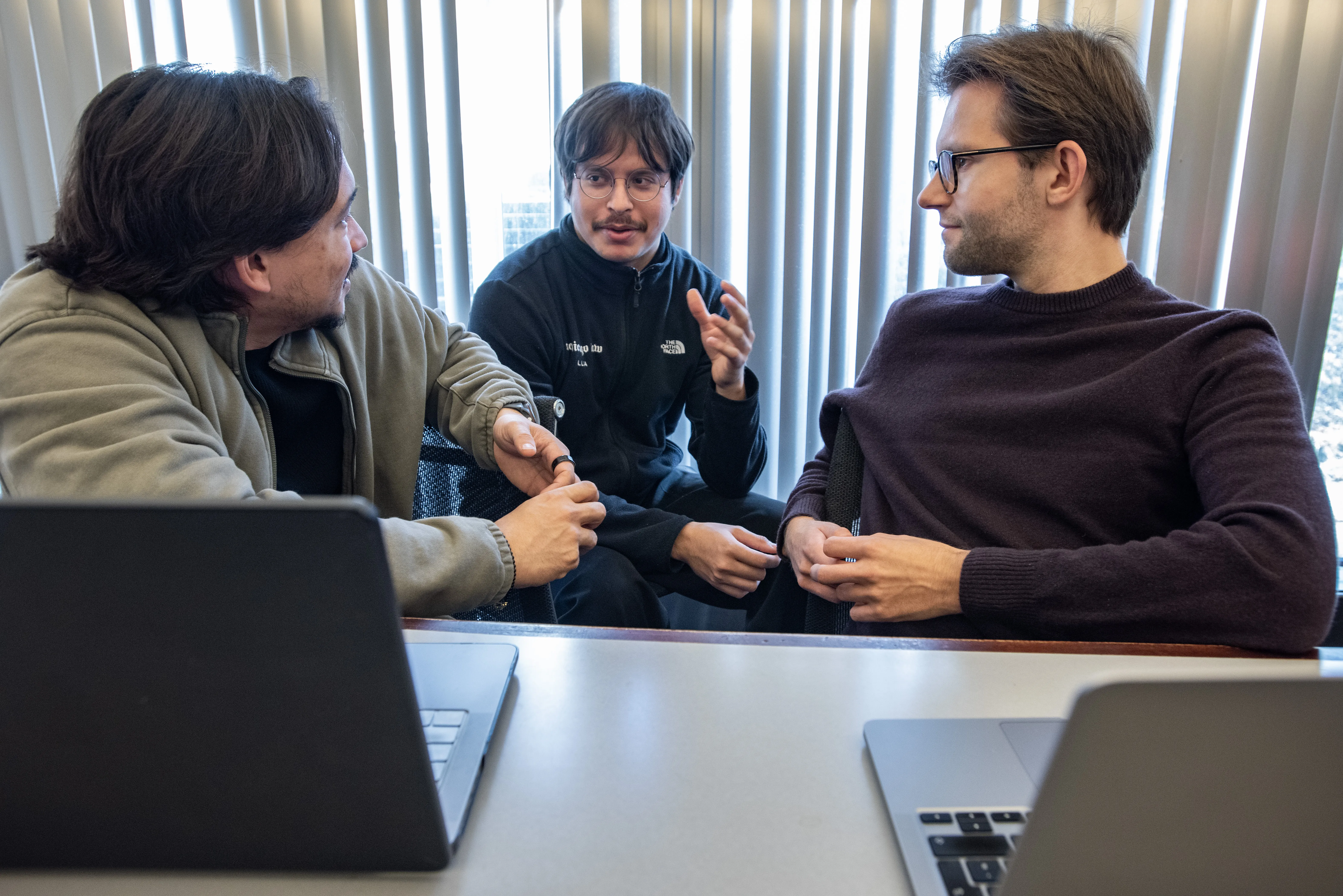 Three students having a discussion in the AI Lab.